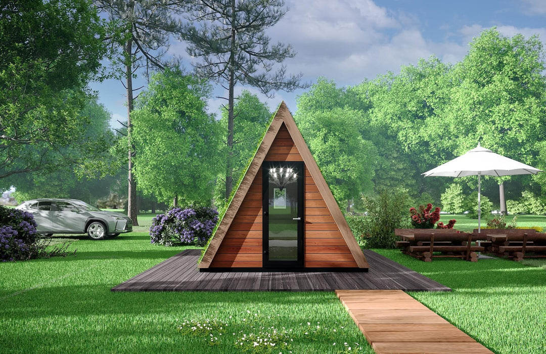 Direct front shot of the A-frame glamping pod with live plant roof, wooden path, and surrounding picnic area and trees.