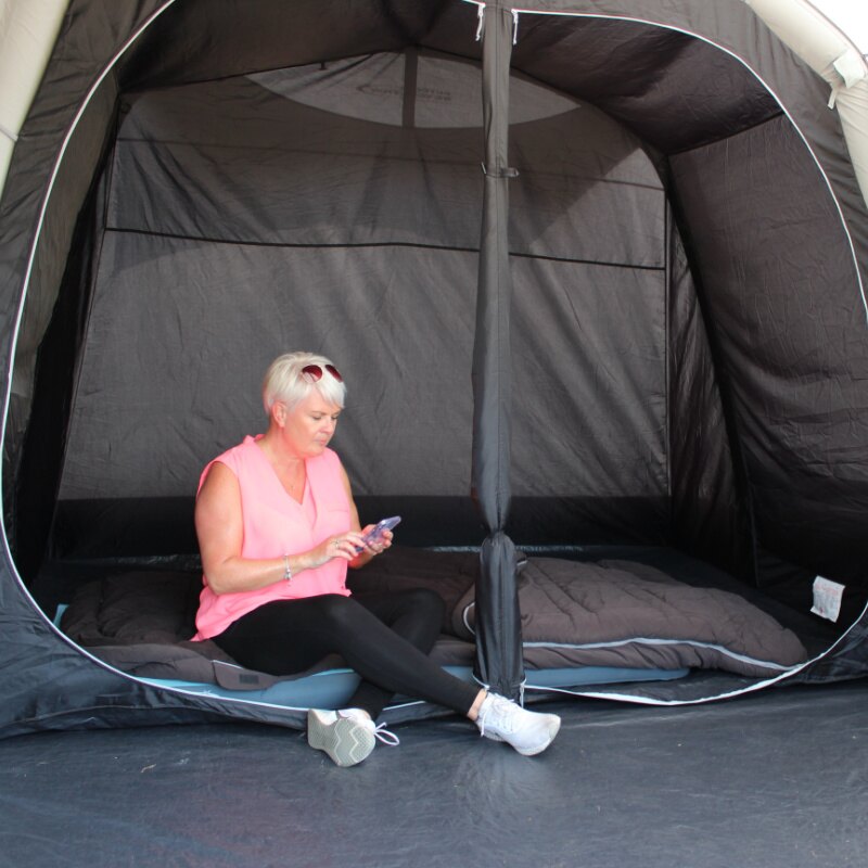 A woman in a pink top sat inside a caravan awning next to the bedroom pod