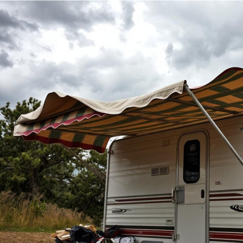 An awning attached to a caravan, the awning is blowing in the wind with a grey sky in the background