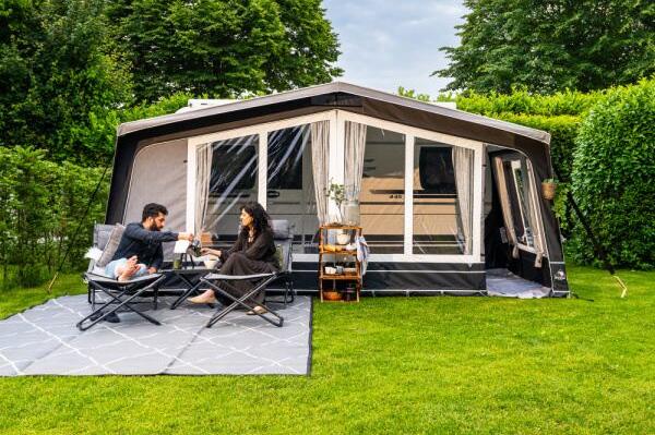 A couple sat in chairs in front of a Dorema awning