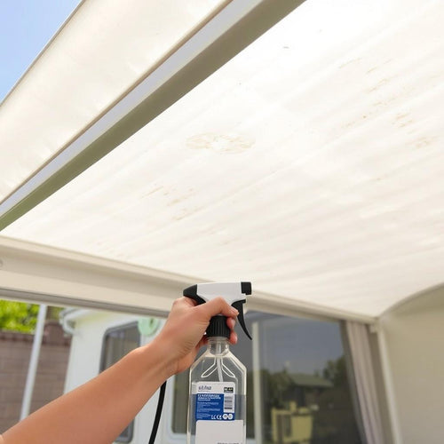 An arm holding a bottle below a light-coloured awning