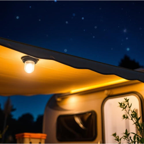 A light bulb underneath a caravan awning with a dark starry sky above
