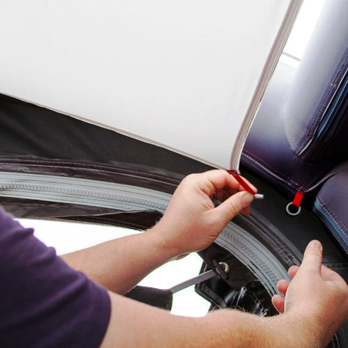 Close up of hands tying together the liner for a caravan awning
