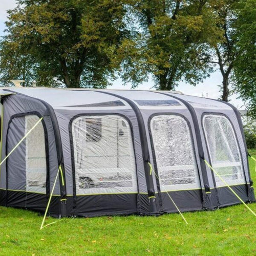 An OLPRO caravan awning shown from the front with grass in front and trees behind