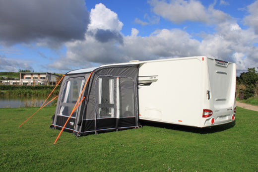 A Camptech Starline Elite 200 Caravan awning in a field connected to a motorhome