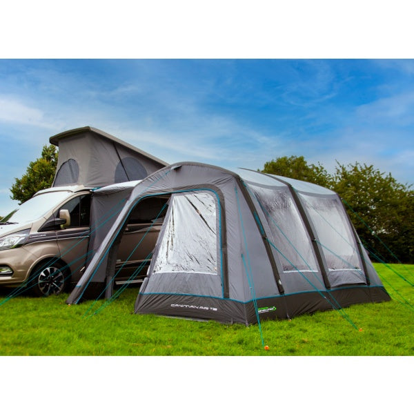 An outdoor revolution awning shown in a field next to a van