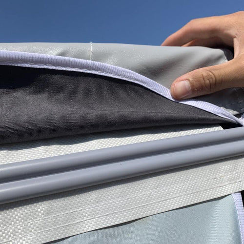 Close up of a hand touching the matierla on a caravan awning