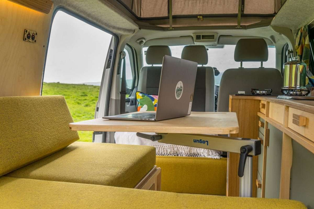 Bivi L Shaped Bed campervan layout showing sofa configuration with integrated storage and light wood interior panels.