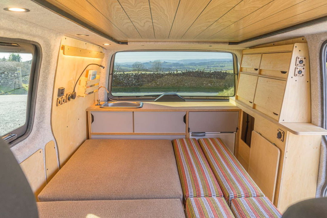 The Campervan Bereau Sideboard interior layout displays the compact kitchen unit with sink, storage cupboards, and a convertible sleeping area arranged efficiently across the van.