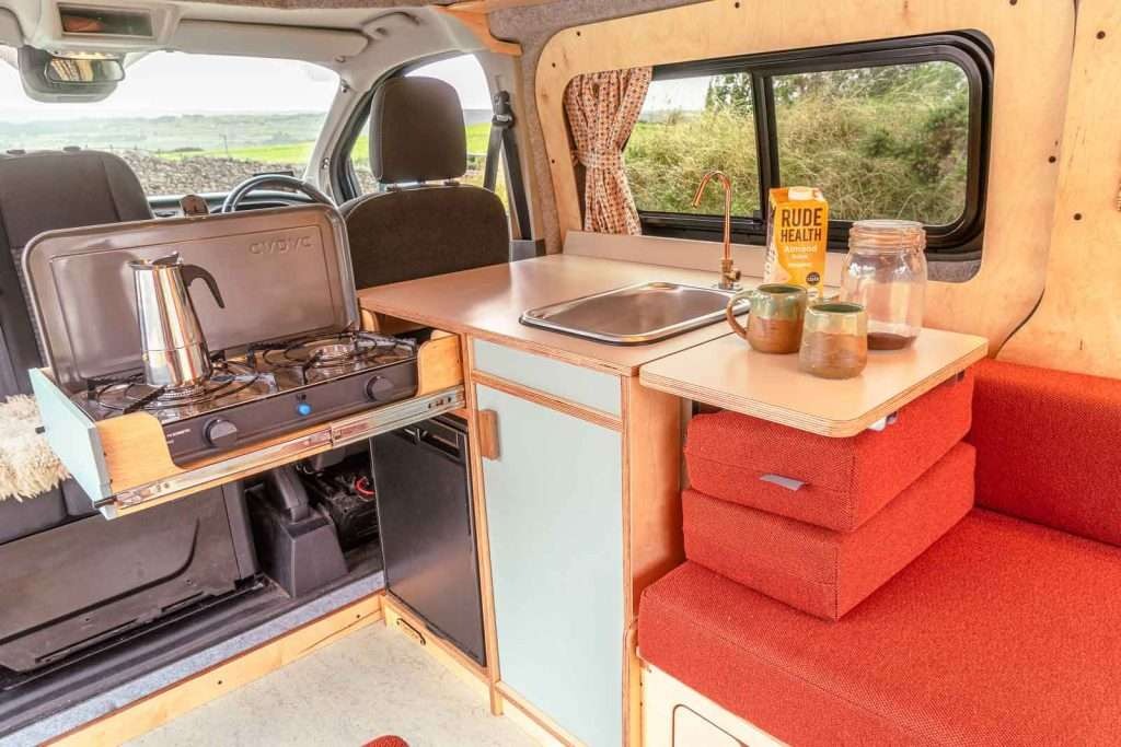 Kitchen preparation view of the Campervan Helm Kitchen Unit with pull-out gas stove, sink, and compact storage inside the campervan.