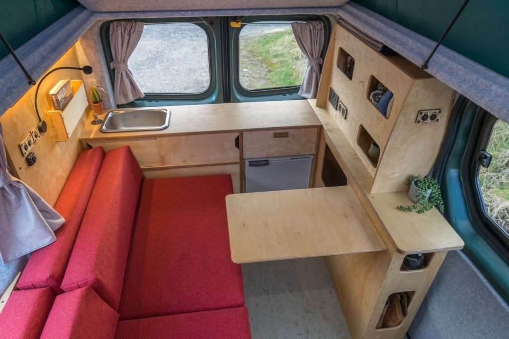 Campervan Ranger Kitchen Unit full interior conversion layout with red bench seating, sink and compact fridge.