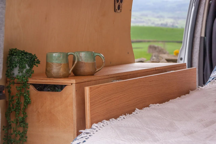 Campervan Rig Sideboard is paired with a cushioned bench seat, demonstrating how the unit combines seating, storage drawers, and a compact kitchen layout.