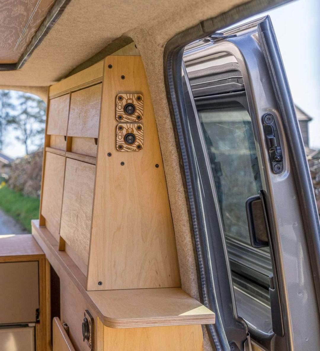 A close-up of the Campervan Bereau Sideboard showcases the layered plywood construction and built-in control switches mounted neatly on the side panel.