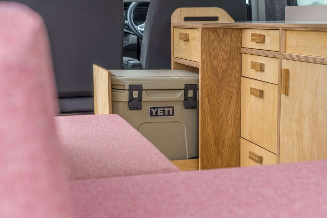 Campervan Squall Kitchen Unit UK version interior with overhead cupboards and integrated sink, natural outdoor background.