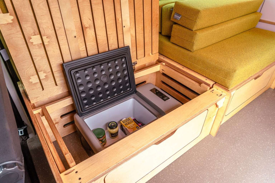 Campervan “Topo” Sofa-Bed with integrated fridge compartment and lift-up bench storage inside a finished campervan conversion.