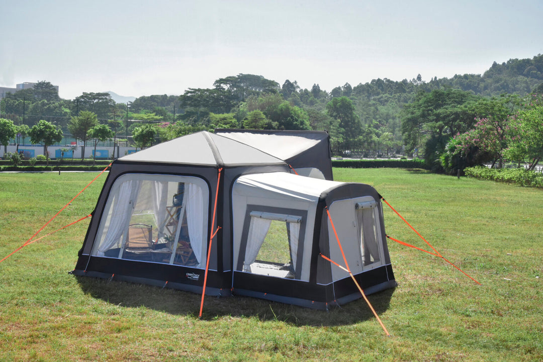 Camptech Moto Crown Elite Tall Annex in grey and black attached to awning on a grassy field.