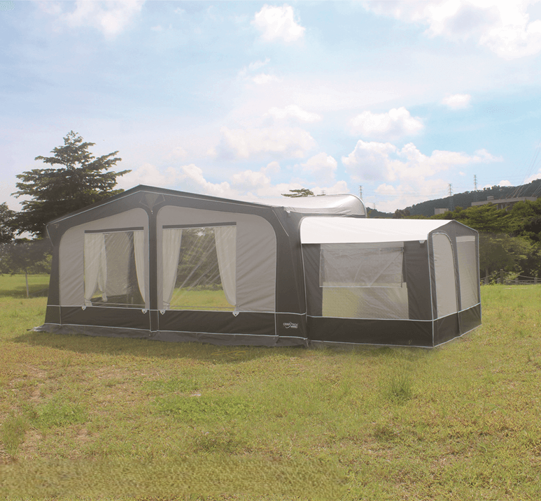 Camptech Tall Annex for Poled Awnings in grey and black attached to an awning on a grassy field.