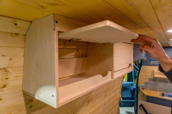 Demonstration of the Campervan Cornice Top Cabinets with one cabinet door lifted open to show the internal storage space.