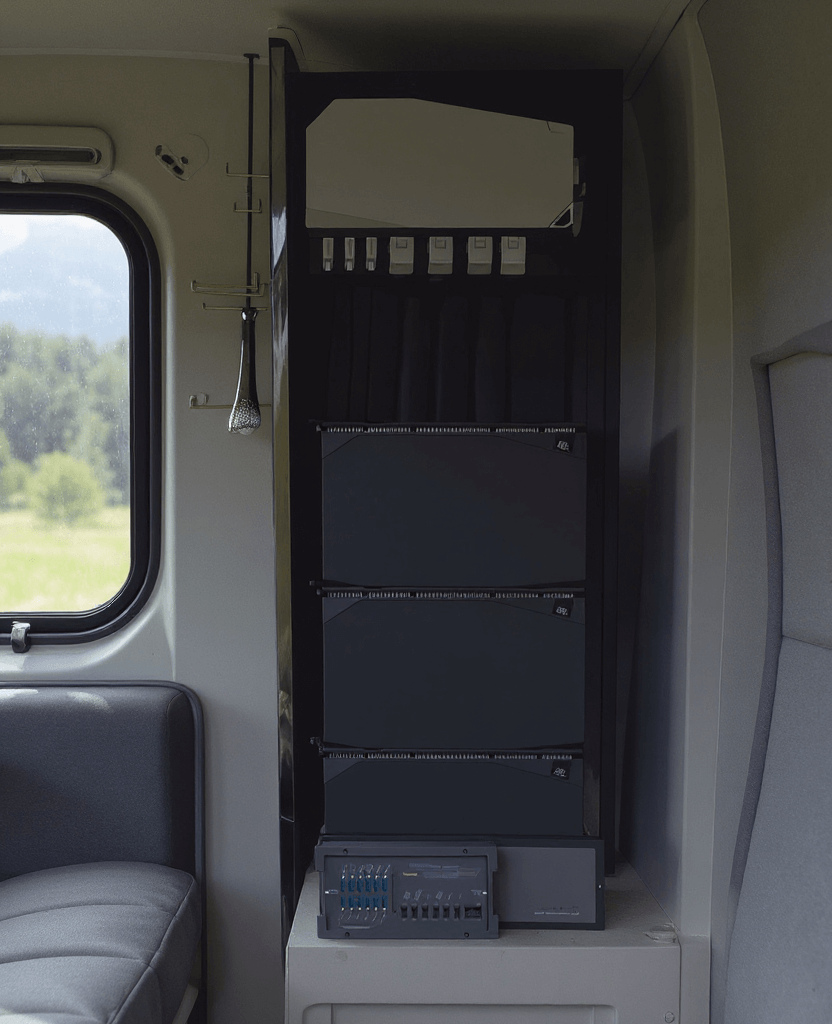  EcoFlow 4kWh Power Kit installed inside a camper van, featuring three stacked battery modules and a control hub neatly integrated into a vertical cabinet beside a window.
