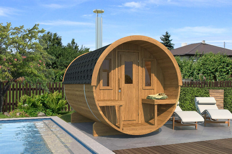 Render of InMedias Barrel Sauna 250 in teak wood variant, showing upgraded darker finish with black roof shingles beside poolside loungers – outdoor garden setting.
