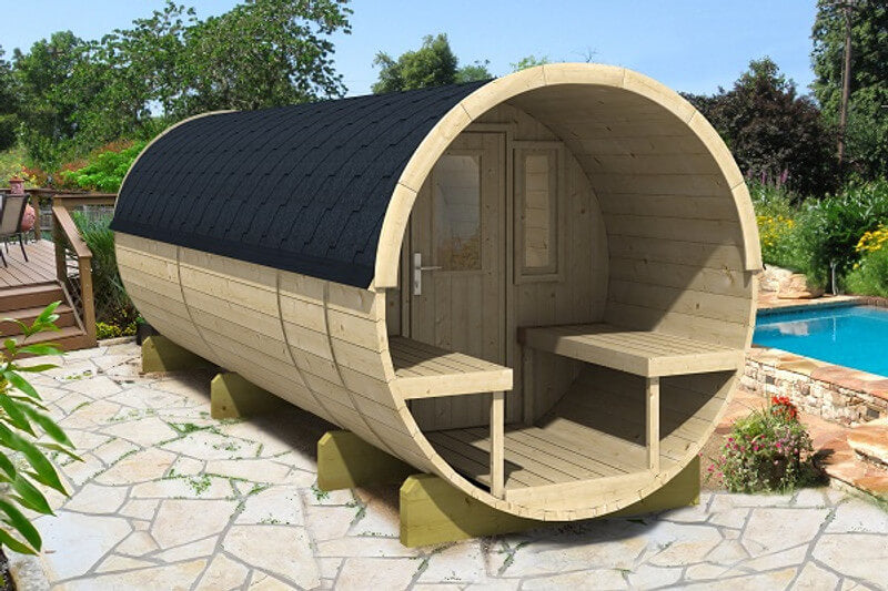 Exterior view of the InMedias Camping Barrel 480, placed on a stone patio beside a pool and surrounded by garden landscaping; on a vibrant outdoor green background.