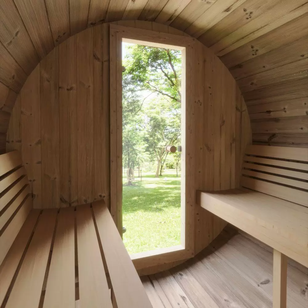 Ergo 220 Barrel Sauna interior with outdoor greenery in the background.