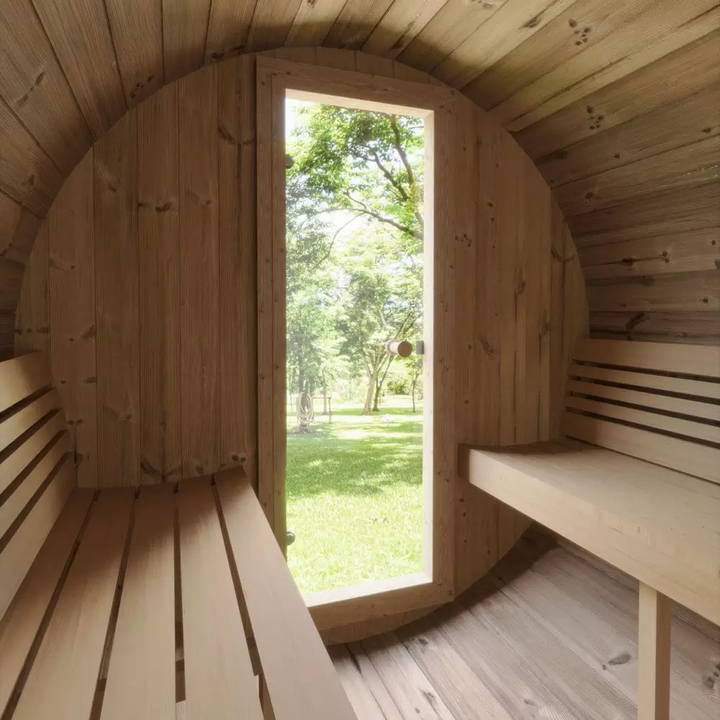 Ergo 220 Barrel Sauna interior with outdoor greenery in the background.