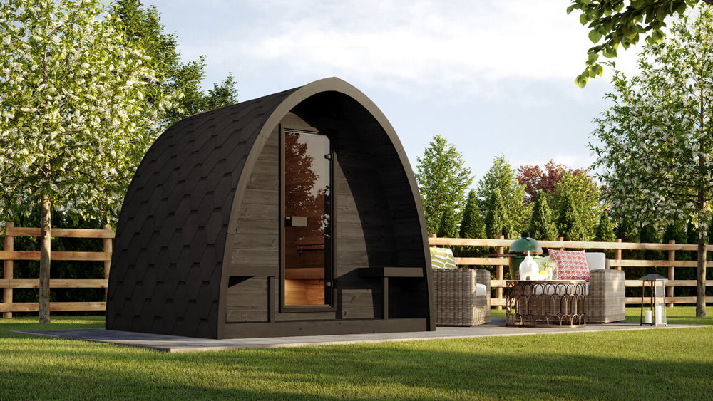 InMedias Sauna Pod 220 4-Person Outdoor Sauna installed in a garden setting with green lawn and trees in the background.