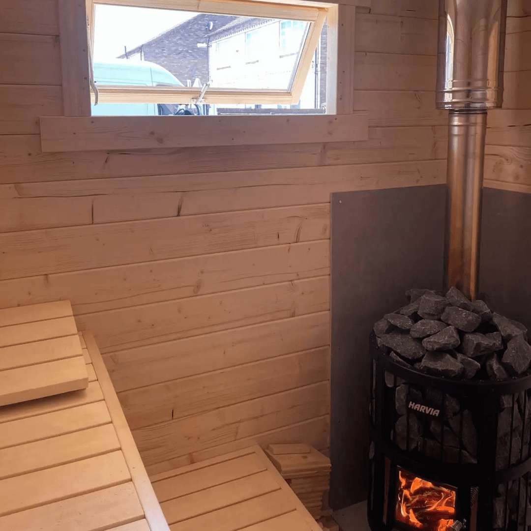 Sauna interior with heater and window inside the InMedias Timo Log Sauna.