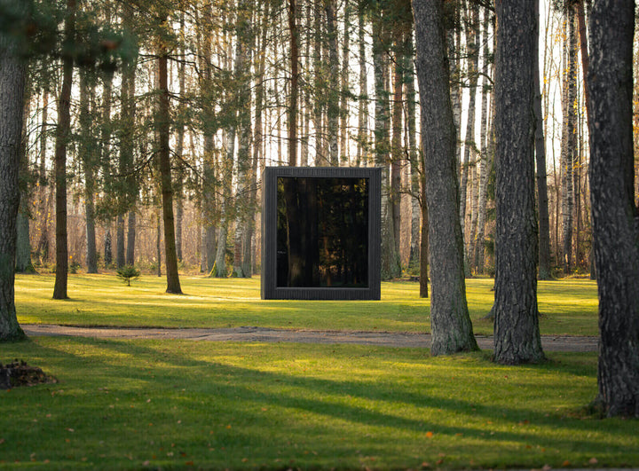 Jonas Classic Outdoor Sauna ebony finish front view, positioned in wooded landscape on grass