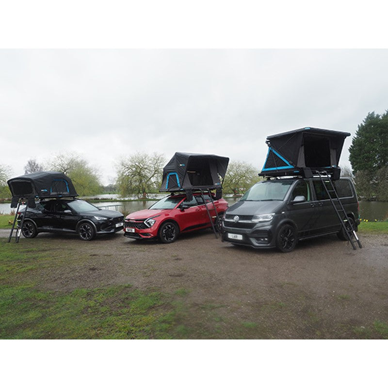 Three cars showcasing Skypod Lair rooftop tents set up with ladders in a countryside field.