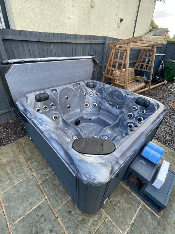 Angled view of Luso Spas The Aquarius Plug & Play Hot Tub showing jet seating layout and headrests on an outdoor background.