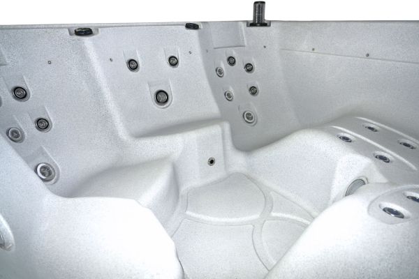 Interior close-up of Luso Spas The Rota Laguna Hot Tub in white granite showing contoured seating and multiple hydrotherapy jets.