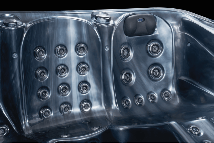 Close-up of Luso Spas The 7000 Hot Tub interior in black marble finish showing hydrotherapy jets and padded headrest.