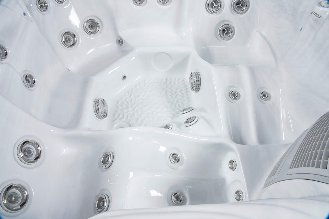 Close-up of Luso Spas The Aquarius Plug & Play Hot Tub interior in white finish showing multiple hydrotherapy jets and textured footwell.