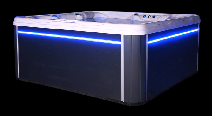Luso Spas The Luna Hot Tub side view with blue LED lighting on a black background.