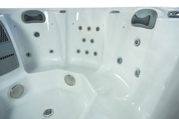 Interior angled view of Luso Spas The Orb Hot Tub in white finish with cushioned headrests and stainless-steel massage jets.