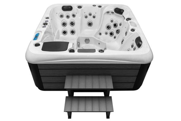 Front view of Luso Spas The Platinum 4 Hot Tub in white acrylic with black steps and wood-style panels, on a white background.