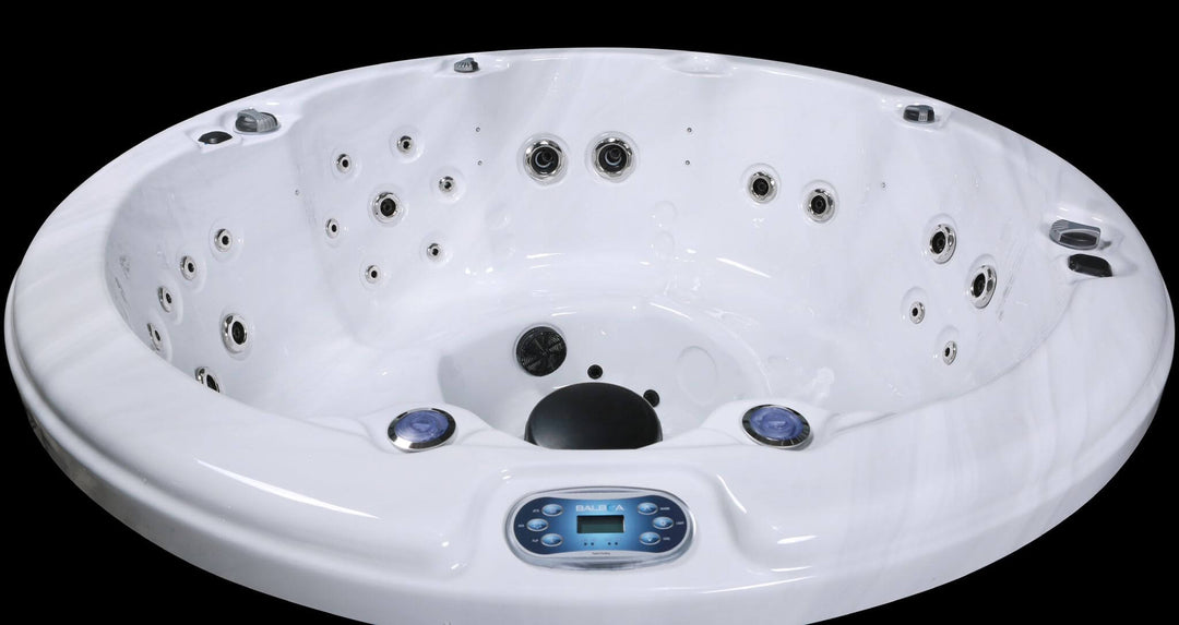 Interior view of Luso Spas The Zodiac Plug & Play Hot Tub showing white acrylic shell, hydrotherapy jets, and Balboa control panel.