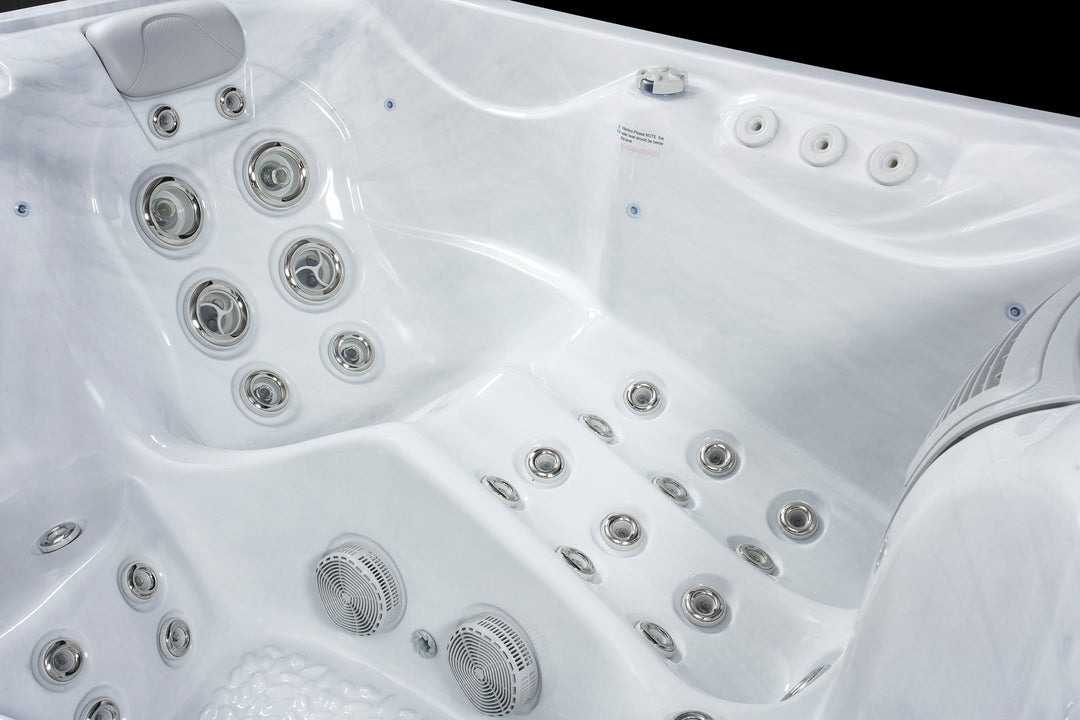 Close-up of white Luso Spas The Vepo Hot Tub interior featuring hydrotherapy jets and speaker system.