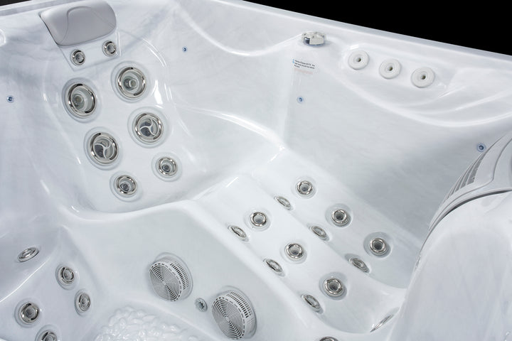 Close-up of white Luso Spas The Vepo Hot Tub interior featuring hydrotherapy jets and speaker system.
