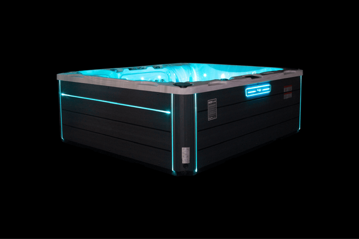 Luso Spas The Maximus Hot Tub illuminated with blue LED lights on a black background.