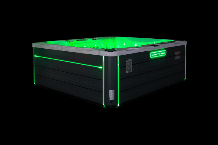 Luso Spas The Maximus Hot Tub illuminated with green LED lights on a black background.