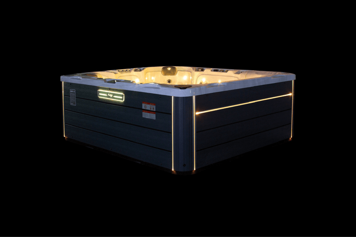 Luso Spas The Maximus Hot Tub illuminated with yellow LED lights on a black background.
