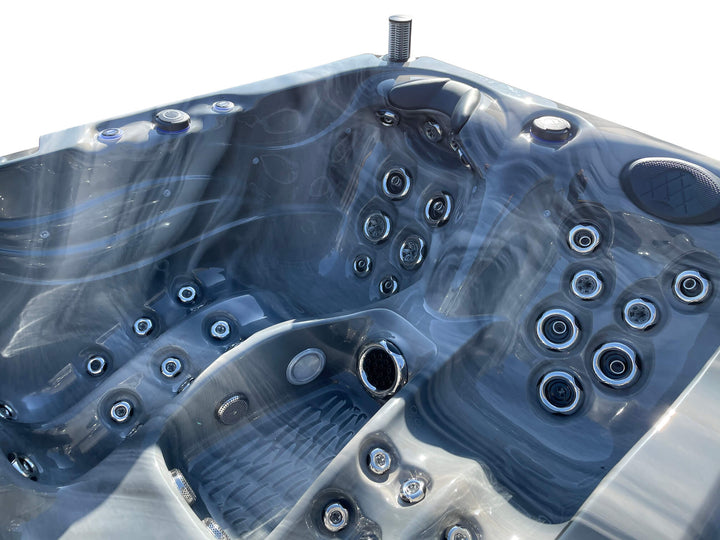Close-up interior view of Luso Spas Luso X300 Hot Tub in dark marble finish highlighting multiple stainless steel jets and seating layout.