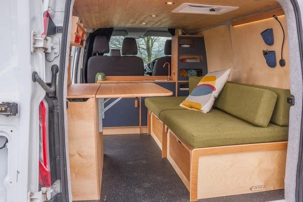 Campervan Navi Kitchen Unit rear view showing fold out table, side bench seating and compact kitchen layout inside a white campervan.