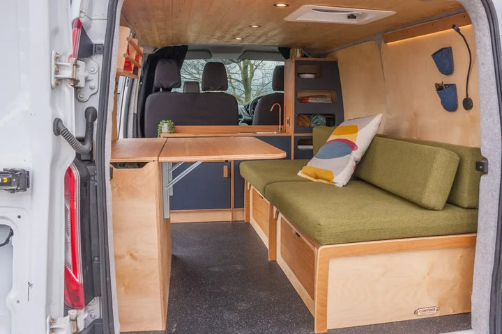 Campervan Navi Kitchen Unit rear view showing fold out table, side bench seating and compact kitchen layout inside a white campervan.