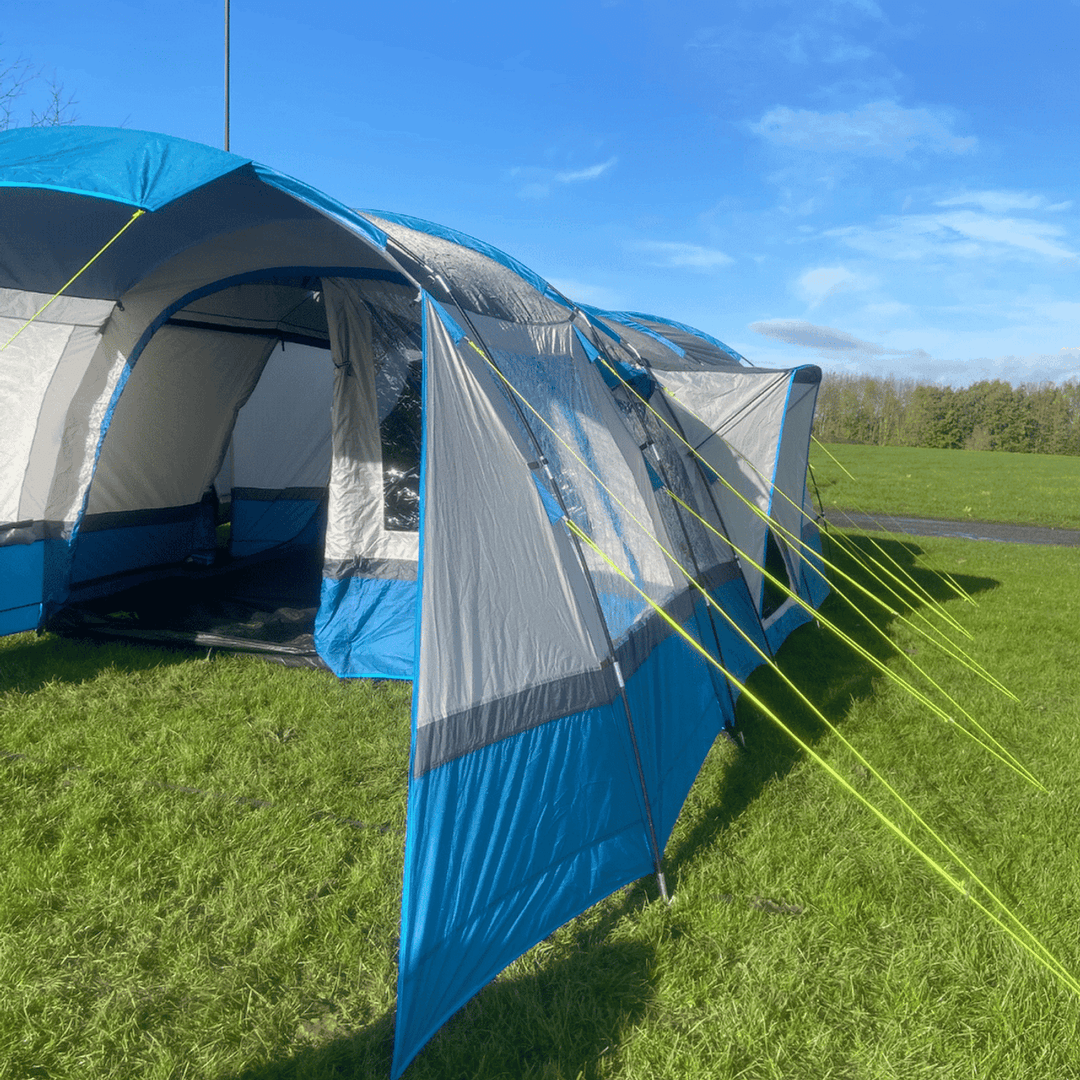 Side angle of OLPRO Cocoon V2 awning with multiple guy lines, pitched on a grassy field.