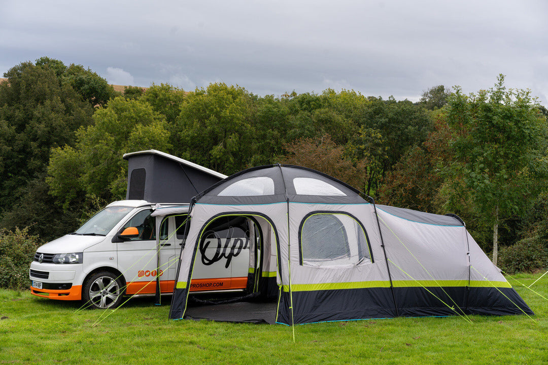 Front view of the OLPRO Hive Campervan Awning connected to a campervan on a grassy campsite.