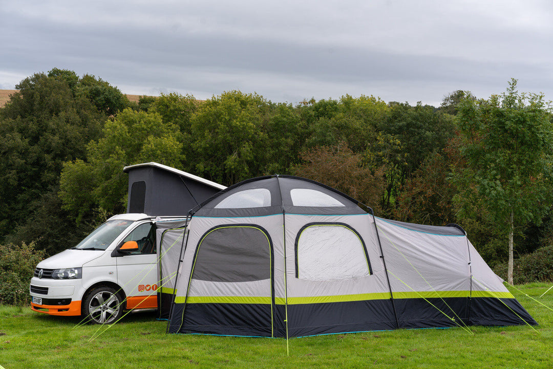 Side view of the OLPRO Hive Campervan Awning attached to a campervan on a grassy hillside campsite.